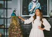 Claire Kettering standing in her home with with a peacock